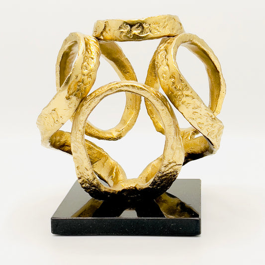 Golden Knot sculpture on a black granite base